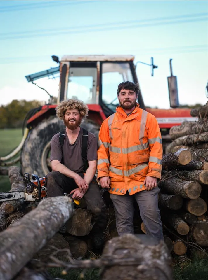 T & H Logs founders Josh and Tom in front of their tractor at the West Sussex yard