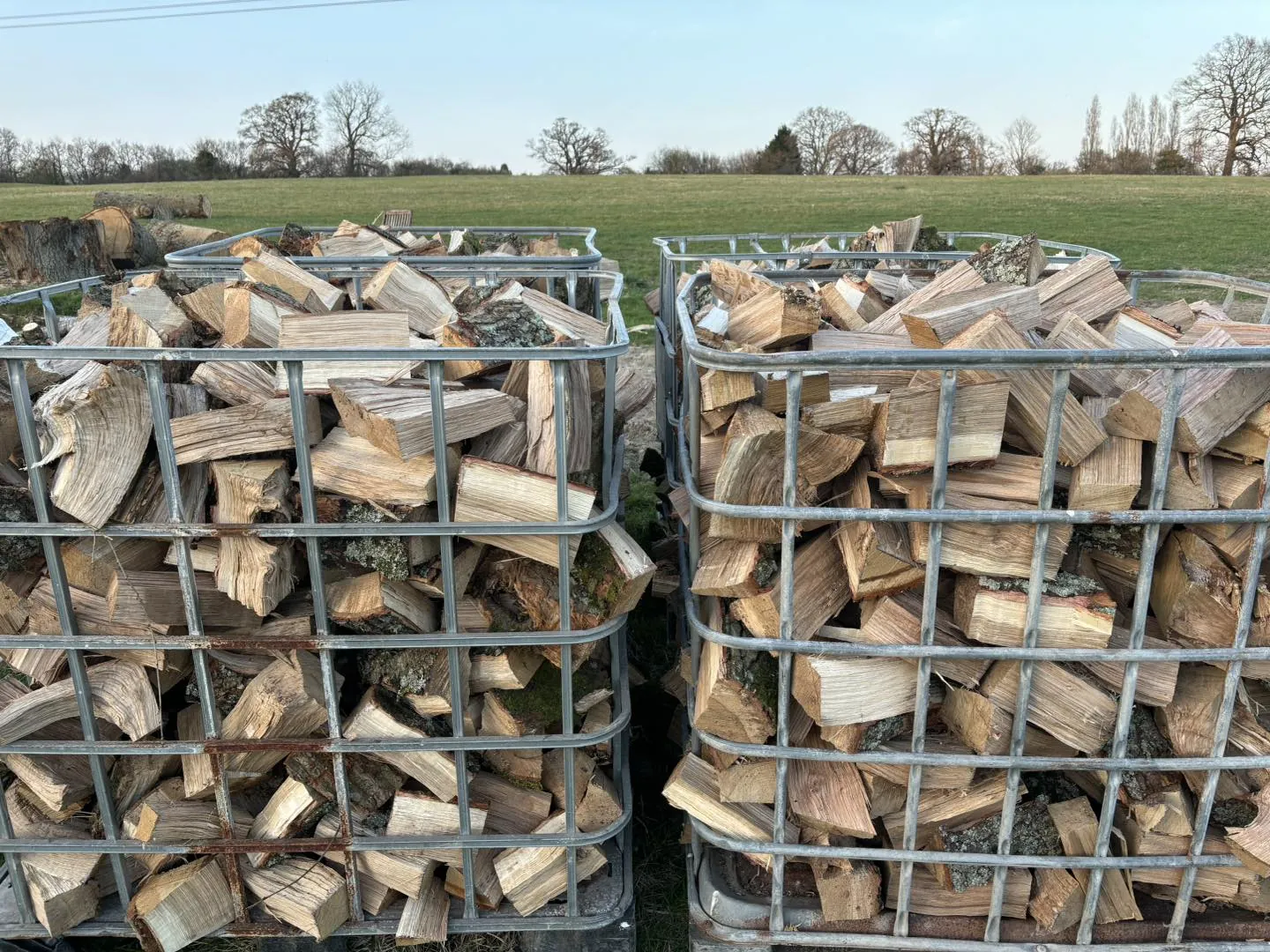 Two metal crates of split seasoned logs