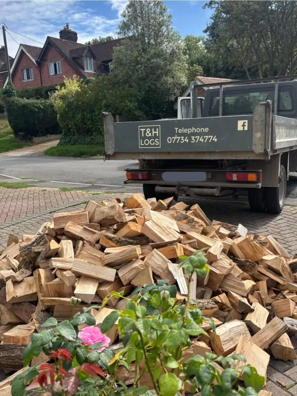 Logs tipped on a driveway behind the T&H Logs truck.